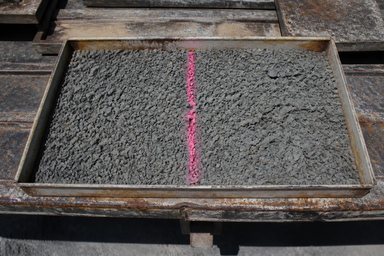 Crushed rock sample divided by an arbitrary fluoro-pink line