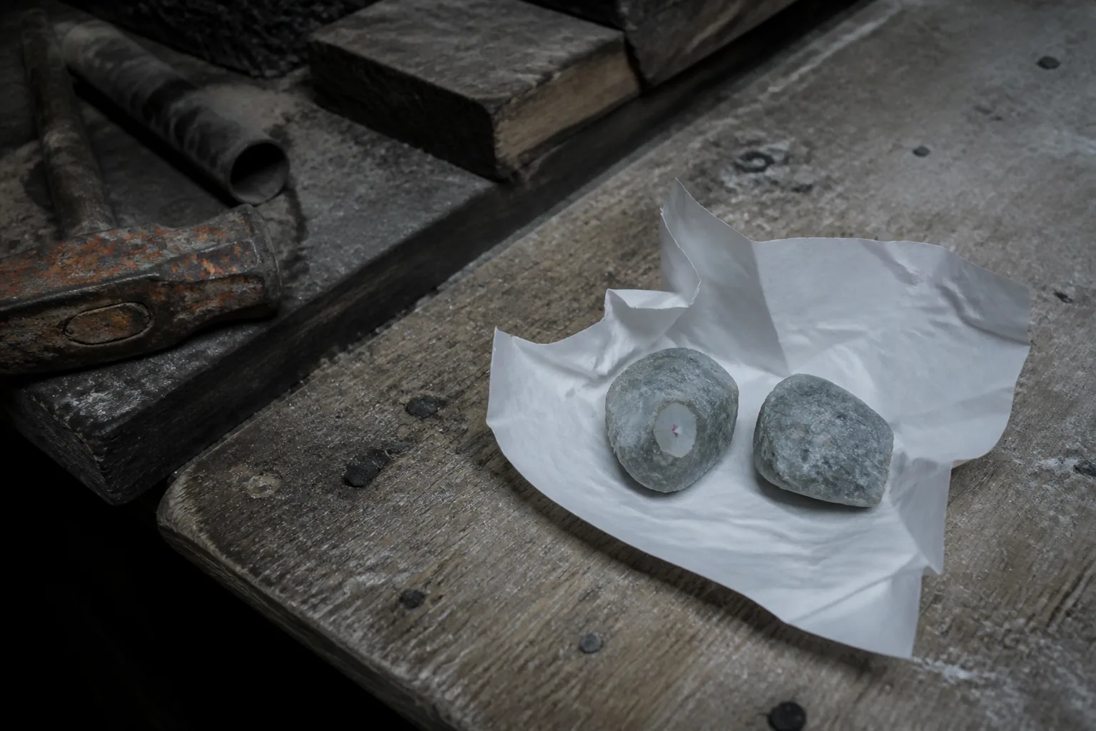 Rough gem parcel with an analytical cut window beside an untouched stone