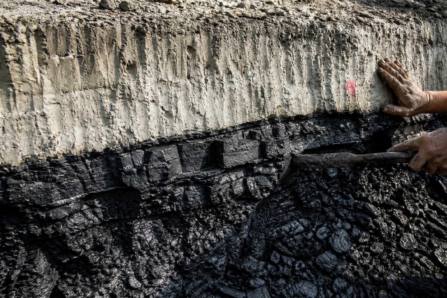 Freshly cut lignite seam meeting compacted clay cover on an active mine bench