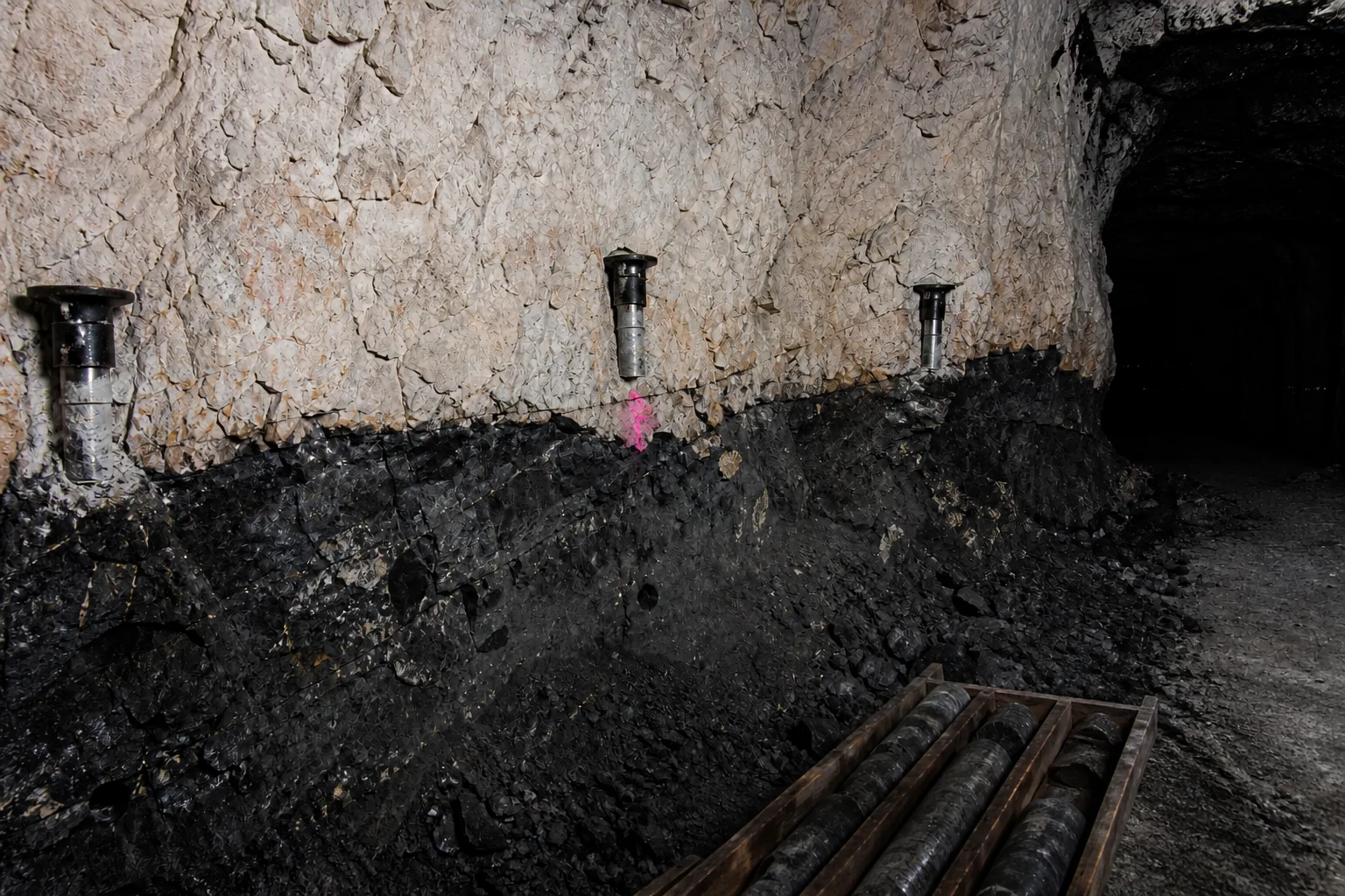 Frozen ore face with marked sandstone-basement contact and freeze collars